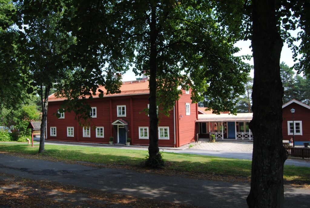 Ett rött hus intill en asfalterad gångväg